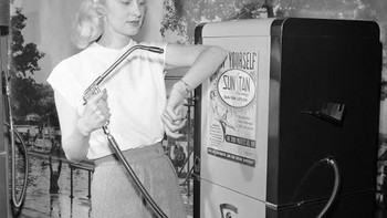Seorang model memperkenalkan vending machine yang isinya lotion tabir surya pada tahun 1949. Sekali bayar, bisa disemprotkan selama 30 detik. Foto: Vintages  