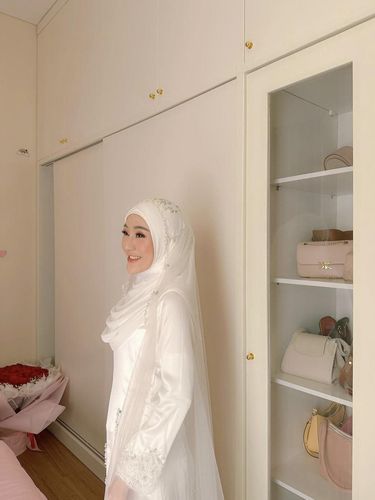 Gaya Larissa Chou menggunakan model hijab dan gaun ala pengantin Melayu.