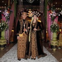 Pada saat resepsi, Selvi Ananda pun tampil memukau dalam balutan kebaya beludru sulaman emas. Kebaya panjang model kutu baru yang dihiasi detail payet, mote dan benang bernuansa emas ini merupakan karya dari desainer Hanif Nanjaya. Foto: Instagram