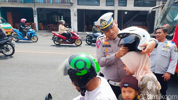 Polisi Beri Helm Pada Pengendara dan Penumpang Motor yang Melanggar Lalulintas