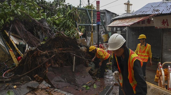 Workers clear debris near shophouses after Typhoon Saola struck the city with strong winds and rain, in Hong Kong, Saturday, Sept. 2, 2023. The typhoon made landfall in southern China before dawn Saturday after nearly 900,000 people were moved to safety and most of Hong Kong and other parts of coastal southern China suspended business, transport and classes. (AP Photo/Billy H.C. Kwok)