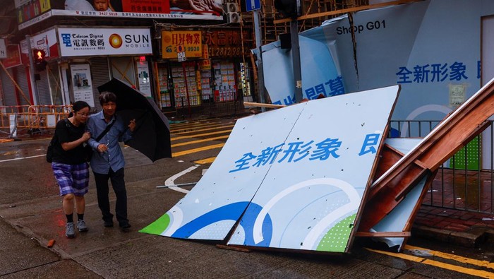 A man walks near fallen trees following Super Typhoon Saola, in Hong Kong, China September 2, 2023. REUTERS/Tyrone Siu
