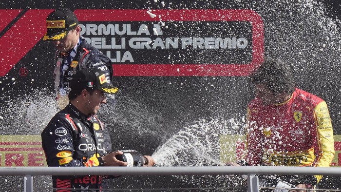 Second placed Red Bull driver Sergio Perez of Mexico, bottom, celebrates on the podium with winner Red Bull driver Max Verstappen of the Netherlands, top, and third Ferrari driver Carlos Sainz of Spain during the Formula One Italian Grand Prix auto race, at the Monza racetrack, in Monza, Italy, Sunday, Sept. 3, 2023. (AP Photo/Luca Bruno)