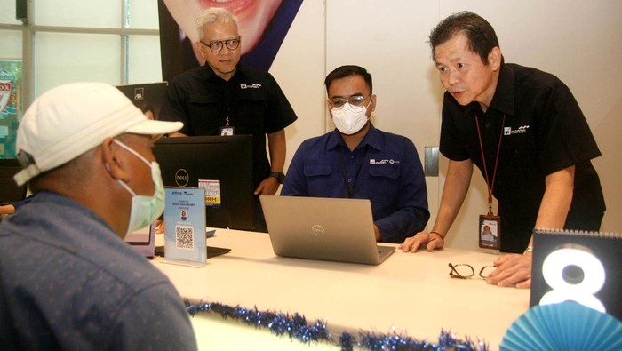 Presiden Direktur PT AXA Mandiri Financial Services (AXA Mandiri) Handojo G. Kusuma menyapa dan melayani nasabah di Hari Pelanggan Nasional 2023 di Jakarta.