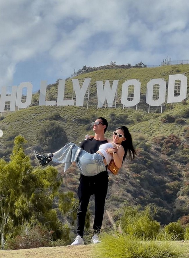 Berpose dengan latar belakang tulisan ‘Hollywood’, Rachel berpose digendong oleh Salim. Foto: dok. Instagram/@rachelvennya