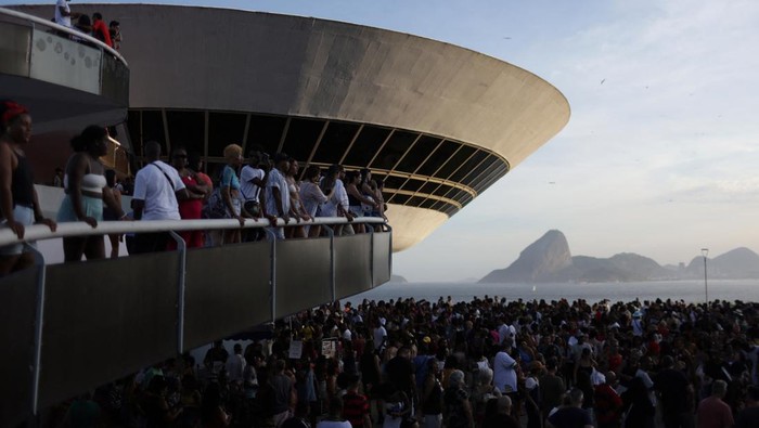 Ribuan Orang Pestapora Rayakan Hari Jadi Museum UFO di Brasil People watch as others participate in the Baile Charme (Charm Dance), a typical cultural dance from Rio de Janeiro, at the Contemporary Art Museum (MAC), known as flying disc or UFO, by the architect Oscar Niemeyer, celebrating its 27th anniversary in Niteroi, Rio de Janeiro state, Brazil September 3, 2023. REUTERS/Pilar Olivares