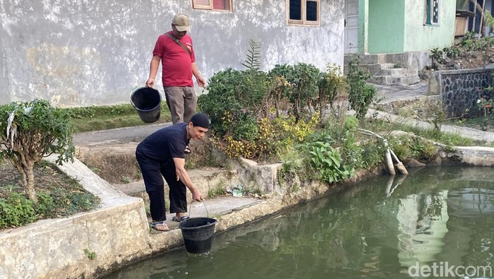 Warga mengambil air dari kolam masjid