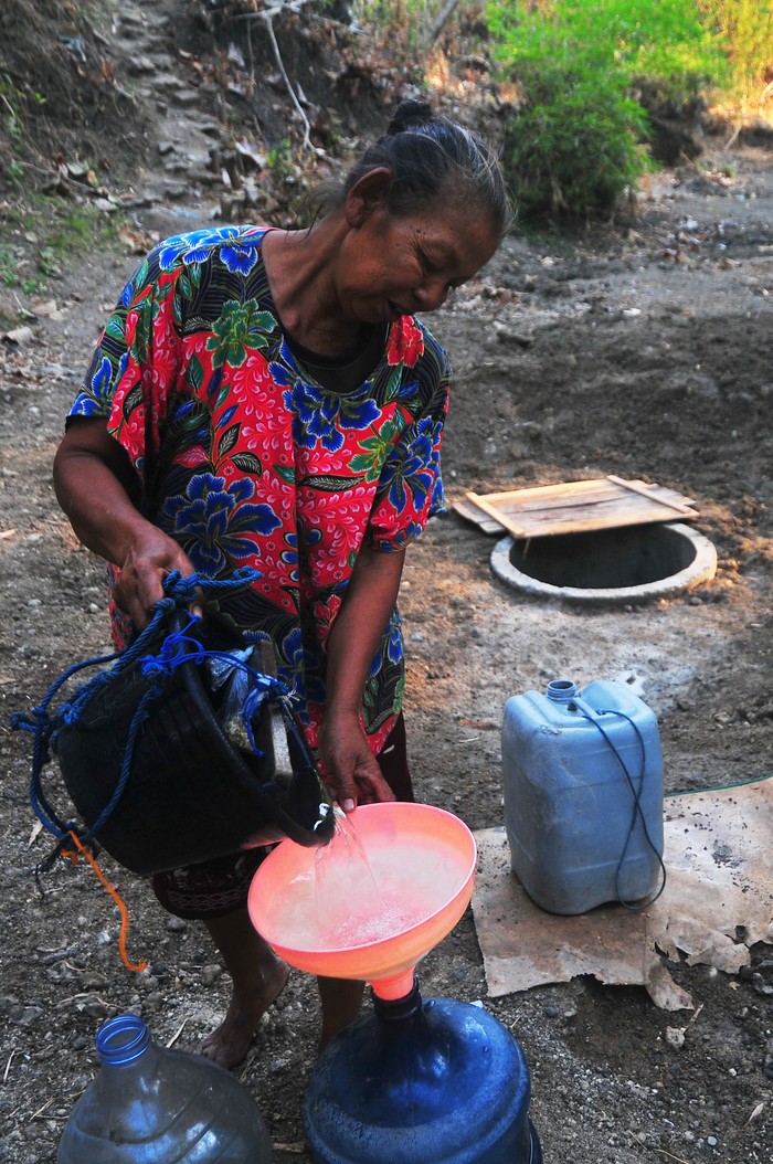 Warga mengisi jeriken dengan air yang diambil dari lubang di dasar sungai di Dukuh Ketro Barat, Karangrayung, Grobogan, Jawa Tengah, Senin (4/9/2023). Menurut data dari Badan Penanggulangan Bencana Daerah (BPBD) Grobogan hingga 4 September 2023, sebanyak 84 desa dari 17 kecamatan di kabupaten itu dilanda bencana kekeringan dan BPBD setempat sudah menyalurkan air bersih ke 78 desa yang terdampak. ANTARA FOTO/Yusuf Nugroho/nym.