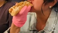 Momennya menikmati hot dog juga tak kalah mencuri perhatian. Ia tampak nikmat sekali makan hot dog dengan isian sosis ayam dan tumisan bawang bombai. Foto: Instagram @dewiperssik9