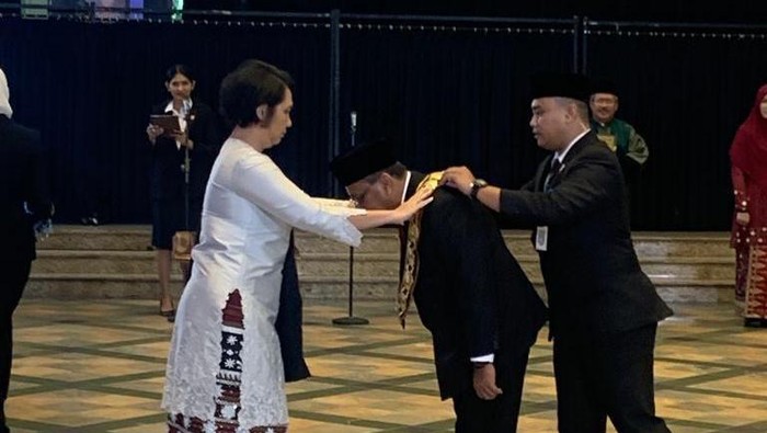 Foto: Pemasangan kalung tanda jabatan rektor oleh Suharti ke Baharuddin (Dok. Unimed)