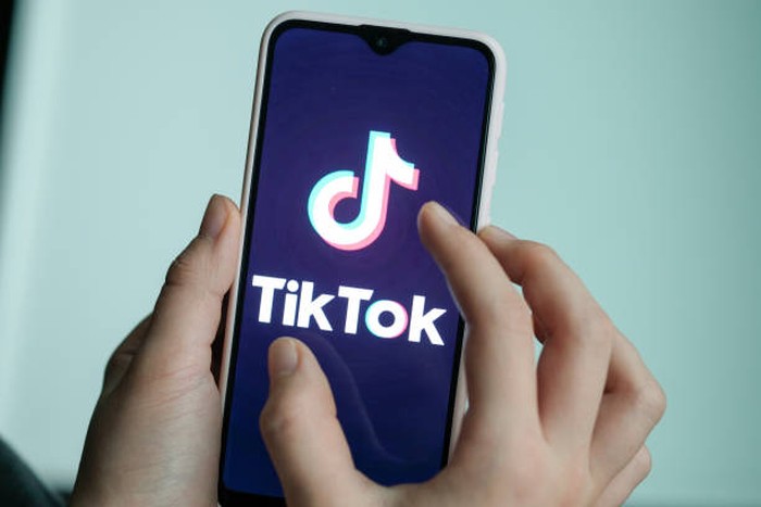 13 November 2019, Berlin: ILLUSTRATION - A girl is holding her smartphone with the logo of the short video app TikTok in her hands. With TikTok, users can create short mobile phone videos to music clips or other videos. Other users can comment on it, distribute hearts or react in any other way. Private messages are also possible. The app is particularly popular with young people. Photo: Jens Kalaene/dpa-Zentralbild/dpa (Photo by Jens Kalaene/picture alliance via Getty Images)
