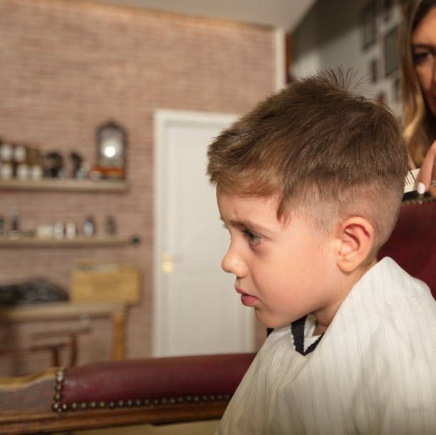 Close up of a child's head at barbershop is getting some hair treatment