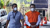 Hasbi Hasan memakai rompi tahanan KPK dengan kedua tangan diborgol. 
