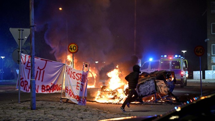 People are silhouetted as cars burn during a riot in Malmo, Sweden September 4, 2023.  TT News Agency/Johan Nilsson via REUTERS      ATTENTION EDITORS - THIS IMAGE WAS PROVIDED BY A THIRD PARTY. SWEDEN OUT. NO COMMERCIAL OR EDITORIAL SALES IN SWEDEN.