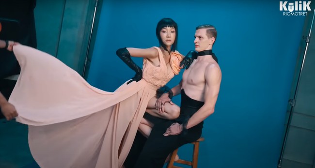 Untuk tema pertama Lucinta Luna tampil dengan riasan wajah glass skin dan dress berwarna salem dengan aksen bunga yang cukup besar di bagian dada kirinya. Sementara Alan tampil topless dan hanya mengenakan bawahan panjang berwarna hitam. Penampilan Alan itu juga dilengkapi dengan choker hitam dan gelang renda yang melingkar di kedua pergelangan tangannya. Foto: YouTube/riomotret