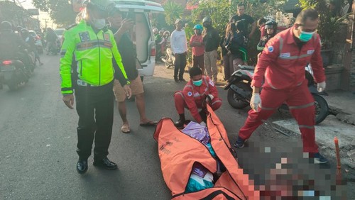 Petugas mengevakuasin perempuan tewas terlindas truk di Badung, Bali.