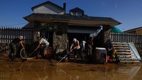 Warga mulai membersihkan lumpur sisa banjir di El Alamo, Spanyol.  