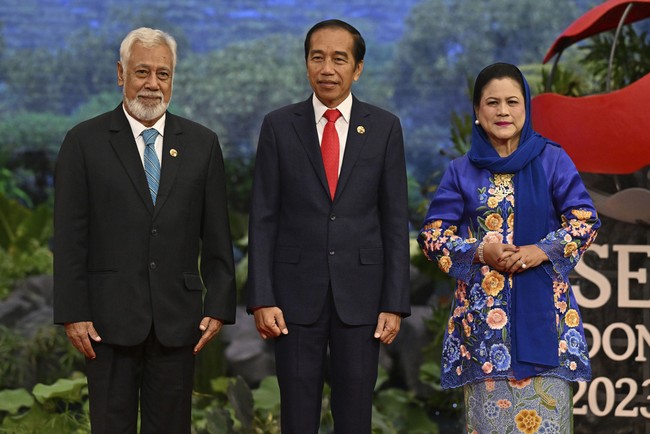 Ibu dua anak ini melengkapi penampilannya dengan kerudung yang juga berwarna biru, disampirkan di kepalanya. Sementara itu, Jokowi mengenakan setelan jas hitam formal serta dasi merah. Foto: AP/Adek Berry