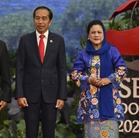 Ibu dua anak ini melengkapi penampilannya dengan kerudung yang juga berwarna biru, disampirkan di kepalanya. Sementara itu, Jokowi mengenakan setelan jas hitam formal serta dasi merah. Foto: AP/Adek Berry