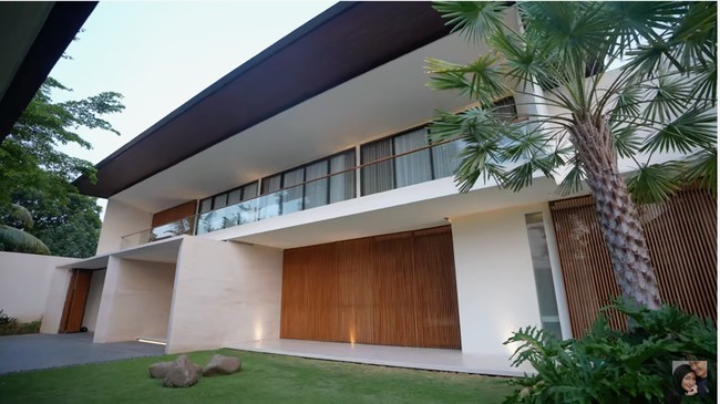 Inilah tampak depan rumah Rezky Aditya dan Citra Kirana. Aura kemewahan sudah terpancar lewat fasad bergaya modern dengan material marmer yang mendominasi, dipermanis sentuhan kayu. Halamannya pun luas. (Foto: YouTube/CikyCitraRezky)