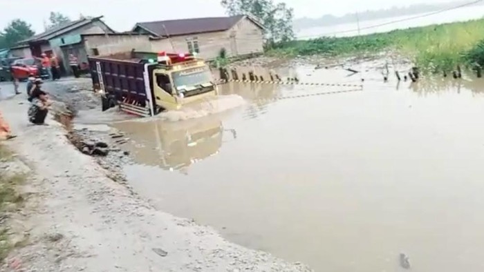 Truk melintas di jalan amblas penghubung Indragiri hulu dan Indragiri Hilir, Riau. (Istimewa)
