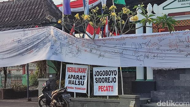 Spanduk yang dipasang warga Sidorejo menuntut agar Jagabaya Kalurahan Sidorejo mundur.