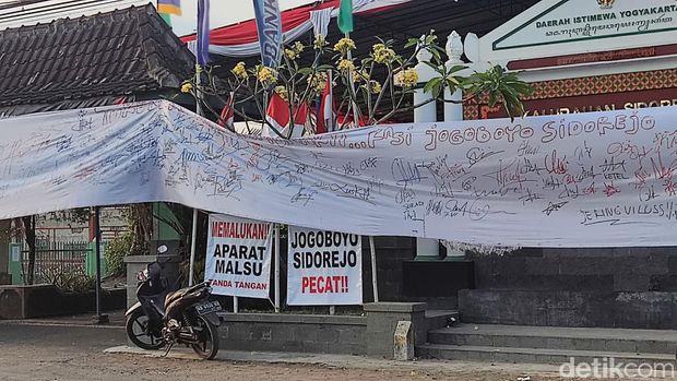 Spanduk yang dipasang warga Sidorejo menuntut agar Jagabaya Kalurahan Sidorejo mundur.