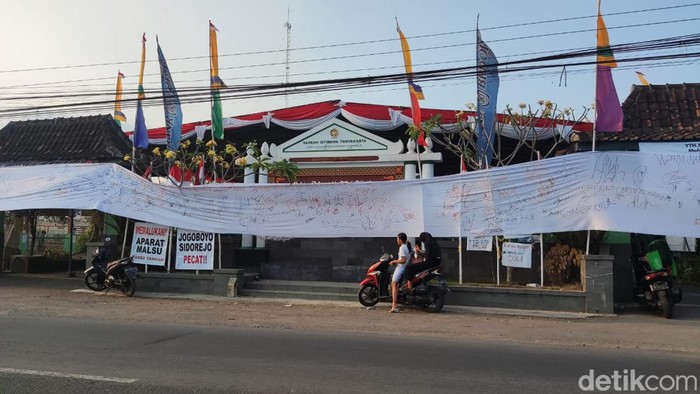 Spanduk yang dipasang warga Sidorejo menuntut agar Jagabaya Kalurahan Sidorejo mundur.