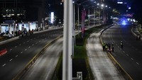 Tak ada kendaraan yang melintas. Hanya petugas kepolisian yang berjaga di jalan tersebut.   