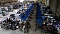 Di sebuah gudang di pinggiran Barcelona, para wanita berdiri di ban berjalan, secara manual menyortir T-shirt, jeans, dan gaun dari tumpukan besar pakaian bekas - sebuah langkah kecil untuk mengatasi masalah fesyen terbuang yang menjulang tinggi di Eropa.  