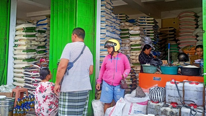 Salah satu pedagang beras yang ada di Pasar Amlapura Timur saat melayani pembeli Selasa (29/8/2023). (I Wayan Selamat Juniasa)