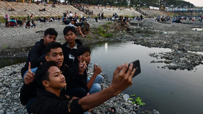 Sejumlah pengunjung berswafoto saat menikmati suasana di kawasan Sungai Madiun, Kota Madiun, Jawa Timur, Kamis (7/9/2023). Sejak sekitar dua bulan terakhir, musim kemarau mengakibatkan sebagian kawasan Sungai Madiun mengering dan menjadi objek wisata alternatif bagi warga dari Madiun serta daerah sekitar. ANTARA FOTO/Siswowidodo/rwa.