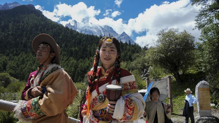 Menjelajahi Cagar Alam Yading di China yang Menyegarkan Mata A Chinese couple wearing Tibetan costumes pose for a souvenir photo against the Chonggu Monastery and snow-capped mountain as they visit the Yading nature reserve in Daocheng county, Ganzi Tibetan Autonomous Prefecture of southwestern China's Sichuan province, Wednesday, Sept. 6, 2023. (AP Photo/Andy Wong)