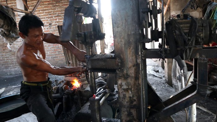 Pandai Besi Mulai Gulung Tikar! Pandai besi membuat sabit menggunakan mesin tempa modern di Desa Puncangsimo, Kecamatan Bandarkedungmulyo, Kabupaten Jombang, Jawa Timur, Kamis (7/9/2023). Keterampilan pandai besi saat ini keberadaannya banyak yang gulung tikar karena tidak adanya penerus dalam mengembangkan usaha, dari sebanyak 25 orang hanya tersisa 10-15 orang pandai besi dan keberadaannya kalah dari mesin pertanian modern. ANTARA FOTO/Syaiful Arif/rwa.