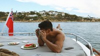 Pria kelahiran 1991 ini juga hobi traveling dan fotografi. Ini momennya saat menikmati pemandangan laut dengan sajian buah semangka yang menyegarkan. Foto: Instagram @tmski