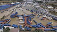 Hujan deras yang melanda menyebabkan banjir bandang di area parkir kontainer dan truk di pinggiran kota.  