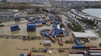 Akibatnya, tumpukan kontainer itu roboh dan berserakan. Banjir terlihat masih menggenang di sekitar area parkir kontainer.