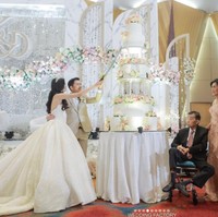 Ada momen di mana Desy Genoveva eks JKT48 dan Kelvin Prasetya memotong kue pernikahan tujuh tingkat berhiaskan lampu dan mawar. Foto: Instagram @desygenoveva_/dok. Wedding Factory