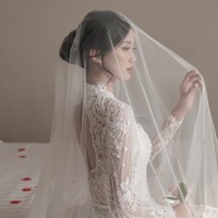 Desy Genoveva eks JKT48 tampil lebih sederhana tapi elegan ketika upacara pemberkatan. Ia mengenakan gaun pengantin berpayet lengan panjang yang transparan pada bagian lengan.  Foto: Instagram @desygenoveva_/dok. Wedding Factory