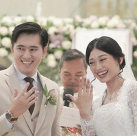 Gaya rambut Desy Genoveva sengaja dibuat berbeda ketika upacara pemberkatan dan resepsi. Ia tampil lebih simple dengan sanggul modern. Foto: Instagram @desygenoveva_/dok. Wedding Factory