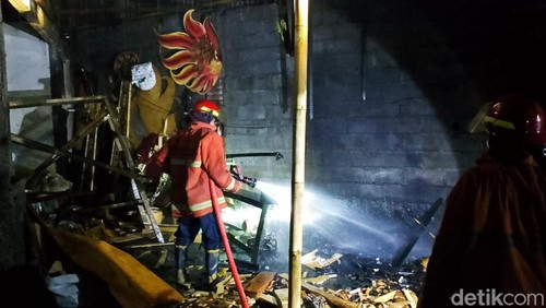 Petugas pemadam kebakaran memadamkan api di gudang pembuatan bade di Karangasem, Bali.