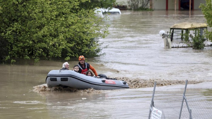 Firefighters with a rubber dinghy evacuee people and dogs from a flooded building in Larissa, central Greece, Wednesday, Sept. 6, 2023. Fierce rainstorms are battering neighboring Greece, Turkey and Bulgaria, causing several deaths. (AP Photo/Vaggelis Kousioras)