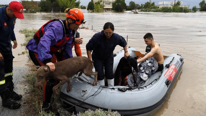 Potret Evakuasi Korban Banjir Bandang di Yunani Firefighters with a rubber dinghy evacuee people and dogs from a flooded building in Larissa, central Greece, Wednesday, Sept. 6, 2023. Fierce rainstorms are battering neighboring Greece, Turkey and Bulgaria, causing several deaths. (AP Photo/Vaggelis Kousioras)
