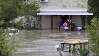 Petugas pemadam kebakaran dengan perahu karet mengevakuasi orang-orang dari gedung yang terendam banjir di Larissa, Yunani tengah, Rabu (6/9/2023).  