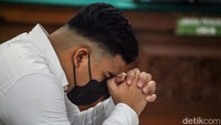 Shane tampak mengepalkan tangan berdoa sebelum sidang dimulai. 
