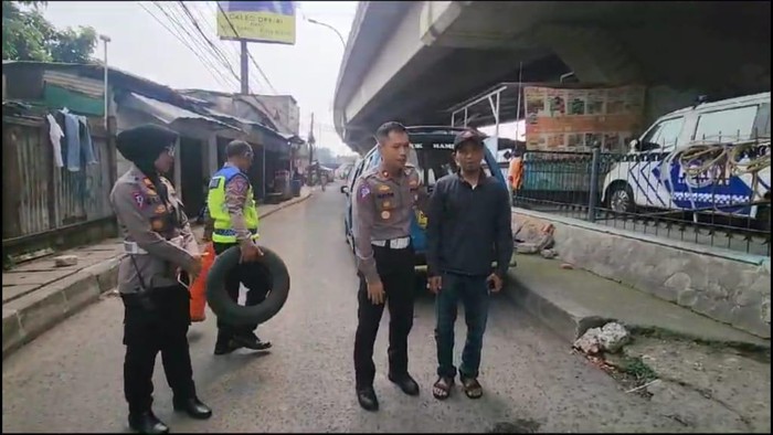 Satlantas Polres Metro Depok mengajar warga untuk mengawasi agar area kolong flyover Jl Arif Rahman Hakim tak diblok oleh angkot yang ngetem.