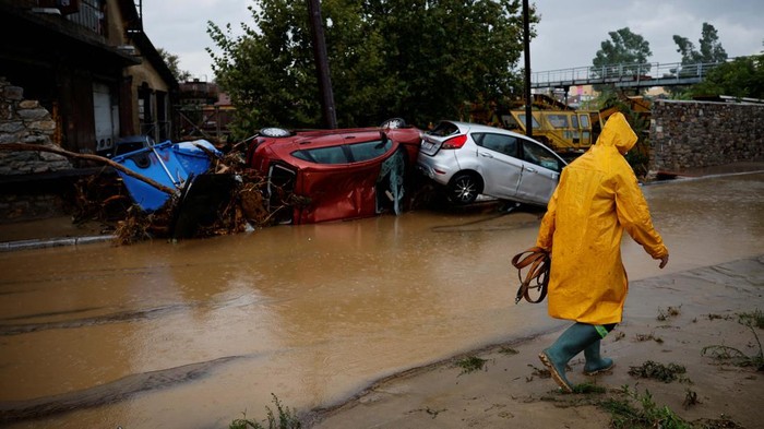 Tersapu Badai Daniel, Mobil Berserakan di Volos Yunani A man holding an umbrella walks on a road flooded due to the impact of storm Daniel, in the city of Volos, Greece, September 6, 2023. REUTERS/Louisa Gouliamaki TPX IMAGES OF THE DAY
