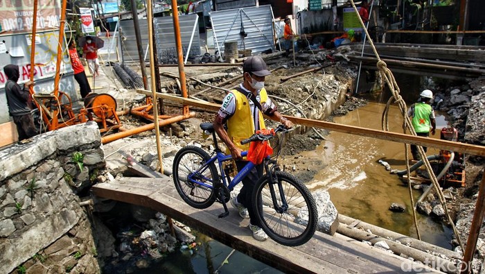 Ada Peninggian Jembatan, Jalan Ceger Raya Tangsel Ditutup 3 bulan Warga berjalan kaki melintasi sungai dengan jembatan seadanya di samping proyek peninggian jembatan di Jl Ceger Raya, Pondok Aren, Tangerang Selatan, Jumat (8/9/2023).