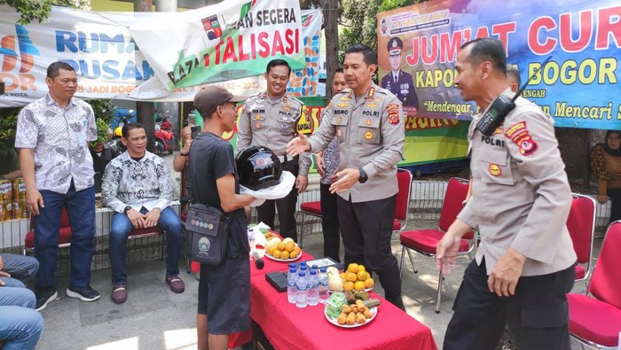 Kapolresta Bogor Kota Kombes Bismo Teguh Prakoso membagikan kontak nomor WhatsApp (WA) kepada warga saat Jumat Curhat. (dok Ist)