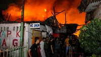 Sejumlah warga membantu memadamkan api yang membakar rumah warga di Jalan Krendang Utara, Tambora, Jakarta, Kamis (7/9/2023) malam. 